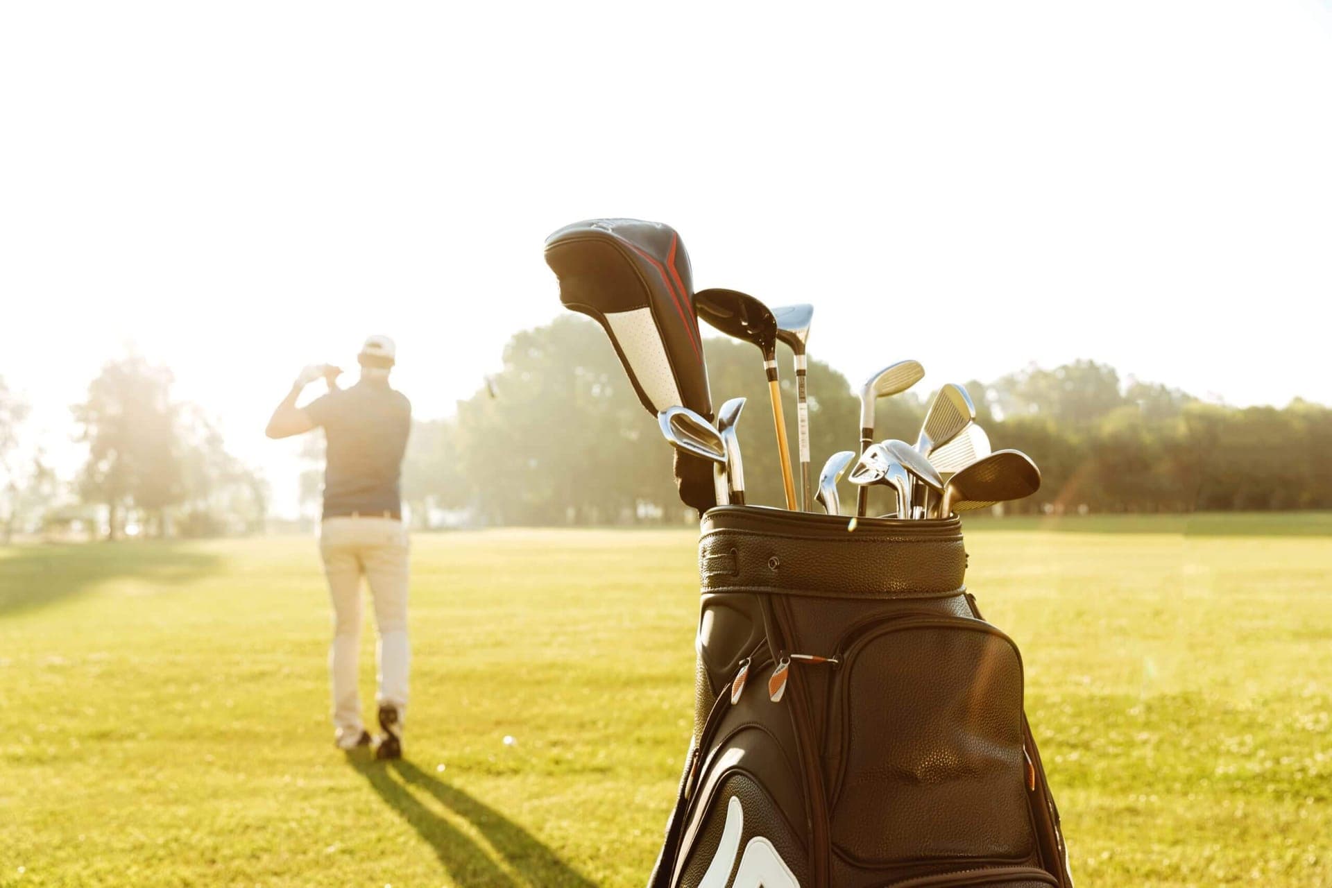 Golfer swinging a club on the green